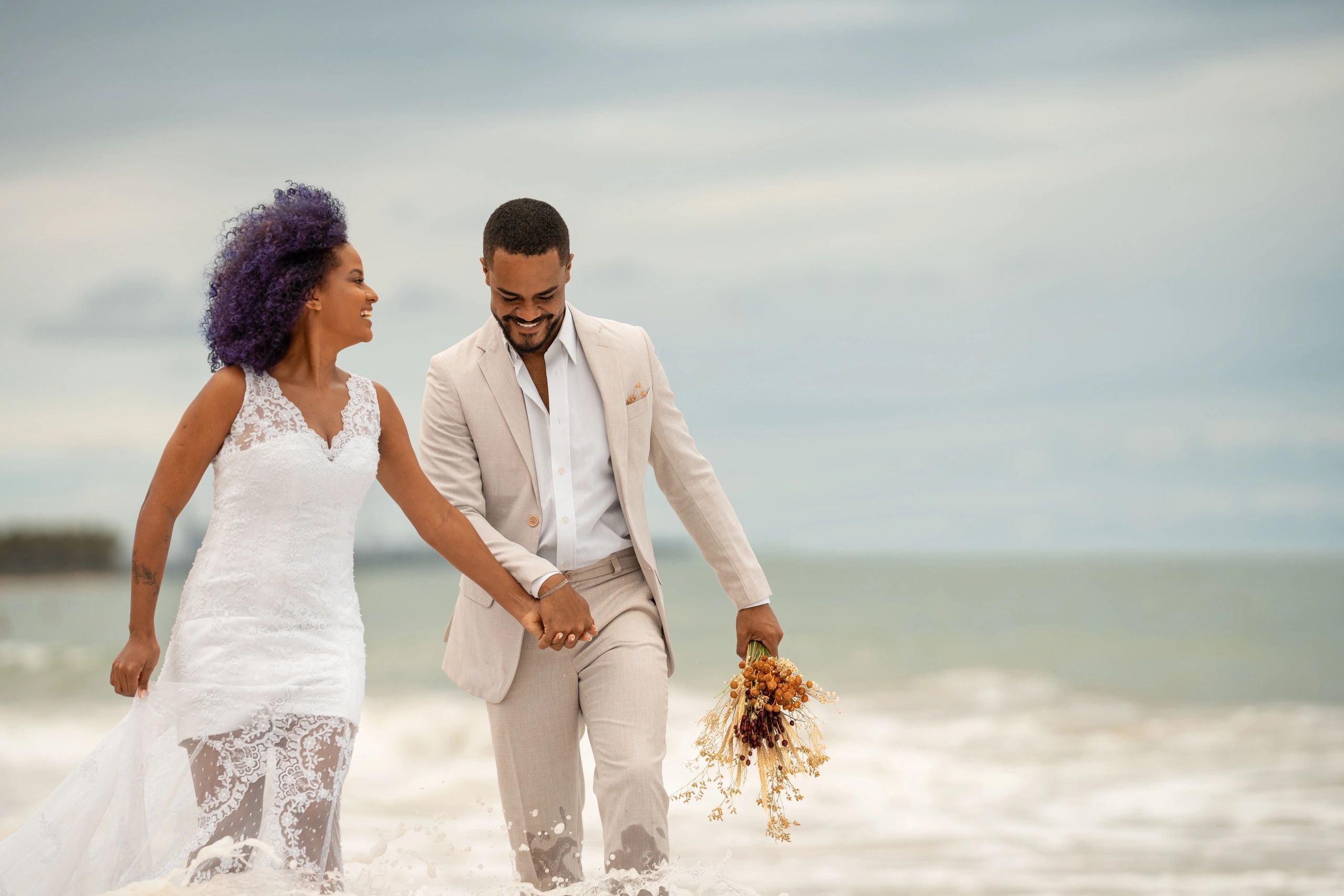 Bride and groom walking by the water