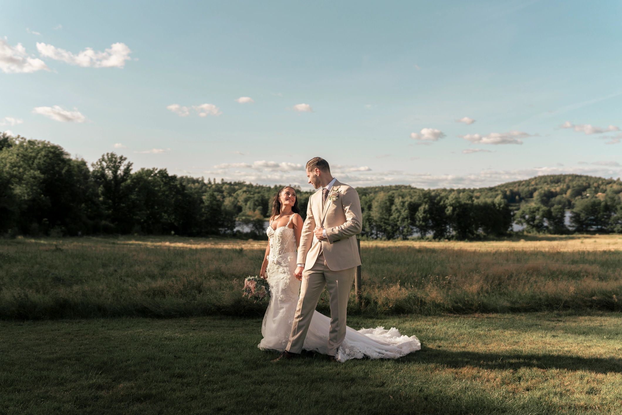 Romantic outdoor wedding portrait of a bride and groom walking hand in hand